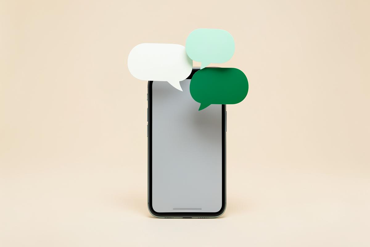 Smartphone with message bubbles floating above it