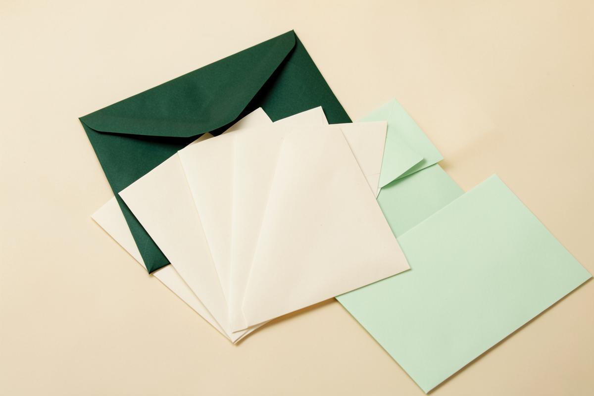 Cream and green envelopes arranged on a desk